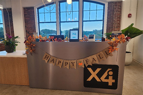 Image shows the X4 reception area decorated with a “Happy Fall” banner.